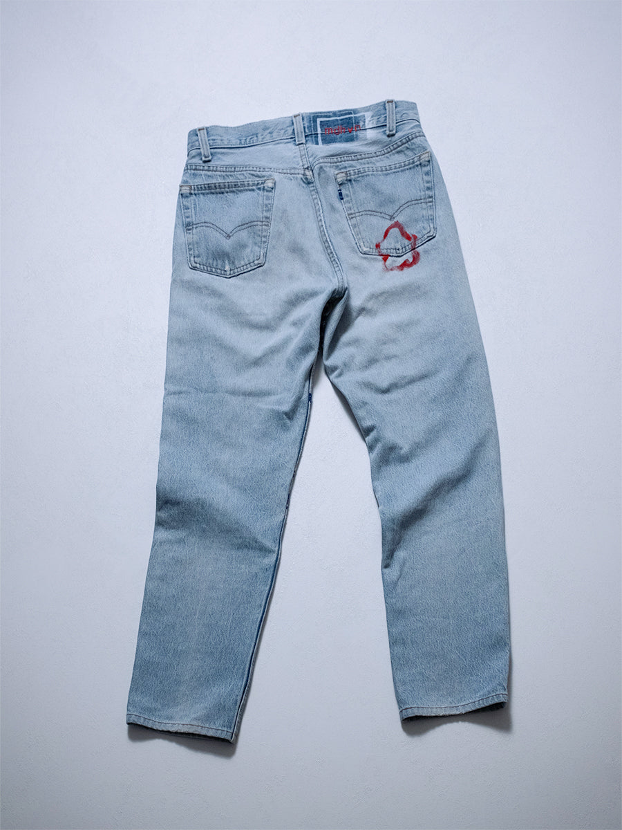Back product shot of upcycled jeans with four-pocket styling and distressing details